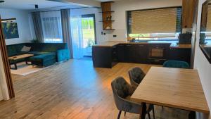 a kitchen and living room with a table and chairs at Szumny Apartment 13a in Brzozówka