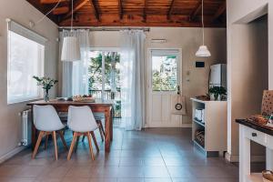 a kitchen with a table and two white chairs at Plenilunio Mar de las Pampas in Mar de las Pampas