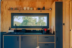 a kitchen with a window and a sink in a kitchen at OtuliLas - Tiny House in Komarno