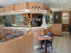 a bar in a restaurant with a small table at Hôtel-Brasserie du marché in Saint-Pierre-du-Regard