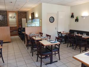 a dining room with wooden tables and chairs at Hôtel-Brasserie du marché in Saint-Pierre-du-Regard