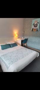 a bedroom with a large white bed with blue pillows at Hôtel-Brasserie du marché in Saint-Pierre-du-Regard