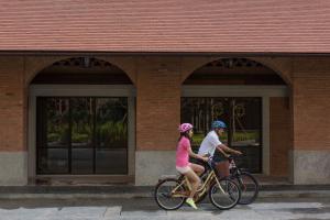 
a woman riding a bike next to a building at U Nimman Chiang Mai - SHA Plus in Chiang Mai
