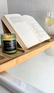 a candle and an open book on a wooden shelf at Seascape Cottage on Kangaroo Island in Baudin Beach