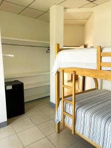a bedroom with a bunk bed and a trashcan at Caracola, habitación privada de Flor de Lis Beach House in Playas