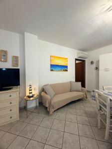 a living room with a couch and a tv at La Terrazza sul Golfo in Golfo Aranci