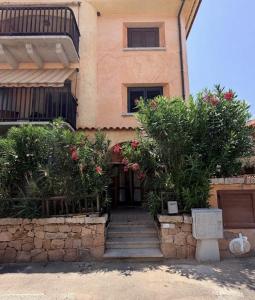 a building with stairs and flowers in front of it at La Terrazza sul Golfo in Golfo Aranci