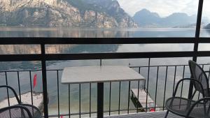 a table and chairs on a balcony overlooking the water at Villa Monica in Malcesine