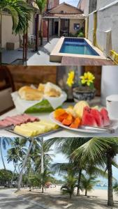 a table with plates of fruit and a swimming pool at Pajuçara Inn - Pousada Maceió in Maceió