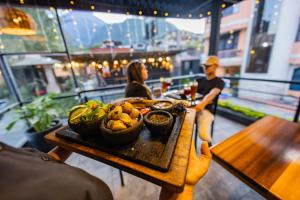 a person holding a table with a bowl of fruit at Casa Tungurahua in Baños
