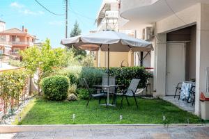 a table and chairs under an umbrella in a yard at Smile studio in Drama