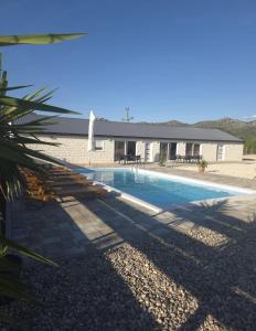 a swimming pool in front of a house at Villa Jopi in Neum
