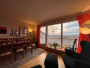 a dining room with a table and a large window at Venusvegen Skyline Views in Tromsø