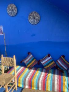 a blue room with a couch and plates on the wall at Casa laila in Chefchaouen