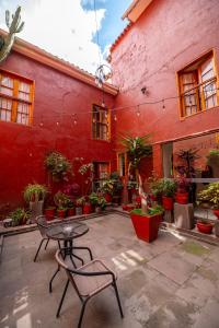 a patio with a table and chairs in front of a red building at San Agustin Internacional in Cusco