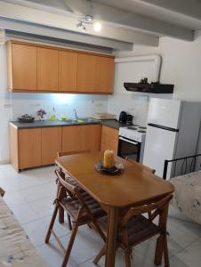 a kitchen with a wooden table and a white refrigerator at Mastic lithos house in Chios