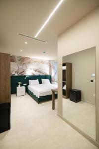 a bedroom with a bed and a large mirror at Otti Hotel in Vlorë