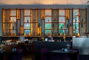 a restaurant with a bar with windows at Del Bono Central Hotel in San Juan