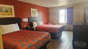 a hotel room with two beds and red walls at Budgetel inn & Suites in Fort Scott