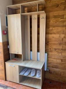a wooden hutch with slippers inside of a room at Готель in Yaremche