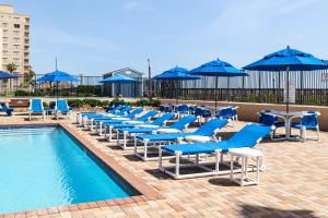 a row of blue chairs and tables next to a pool at Updated 3BR w/ Gulf Views: Suntide III - Unit 801 in South Padre Island