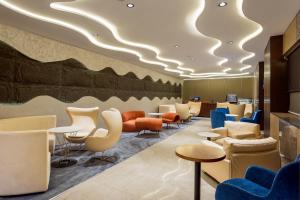 a waiting room with chairs and tables at Best Western Plus Ambience Hotel Ikeja in Ikeja
