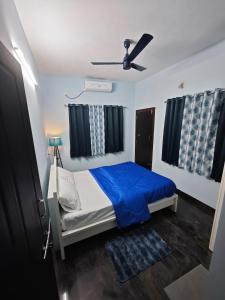 a bedroom with a bed and a ceiling fan at The Reset House Mangalore in Mangalore