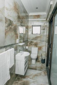 a bathroom with a sink and a toilet at Beck Apartments - Kitwe in Kitwe