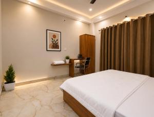 a bedroom with a bed and a desk in it at Eve Service apartment in Mysore