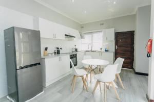 a kitchen with a table and chairs and a refrigerator at Beck Apartments - Kitwe in Kitwe +13 photos