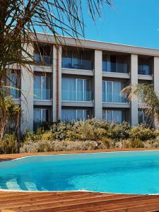 an apartment building with a swimming pool in front of it at Metamare in Cozze