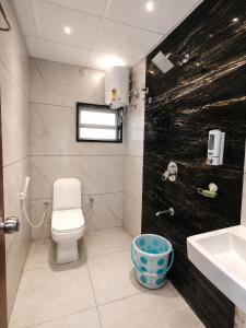 a bathroom with a toilet and a sink at Eve Service apartment in Mysore +26 photos