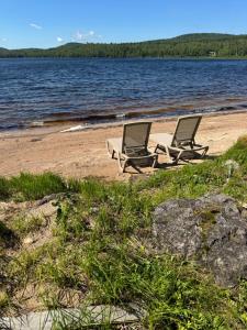 two chairs sitting on a beach next to the water at The Boardwalk in Westfield Beach +20 photos