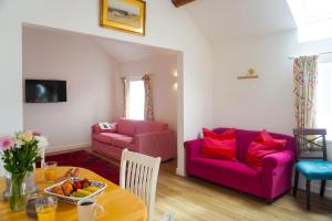 a living room with a table and a purple couch at Bron Haul in Newborough