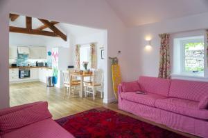 a living room with a purple couch and a kitchen at Bron Haul in Newborough