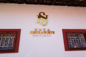 a sign on a white wall with two windows at Casa Sierra Norte in Zacatlán