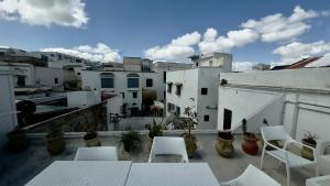 a balcony with white chairs and tables and buildings at bayt el yemin in Kasbah