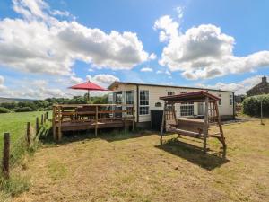 a trailer with a picnic table and an umbrella at Hawks View Caravan in Macclesfield