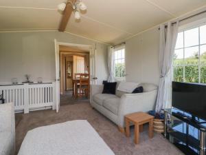 a living room with a couch and a tv at Hawks View Caravan in Macclesfield
