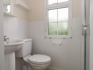 a bathroom with a toilet and a sink and a window at Hawks View Caravan in Macclesfield +15 photos