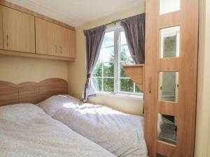 a bedroom with a bed and a window at Hawks View Caravan in Macclesfield