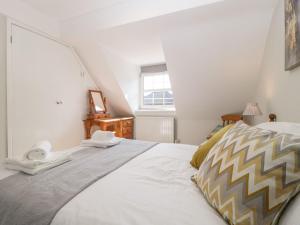 a bedroom with a large bed with two towels on it at The Cottage in Salisbury