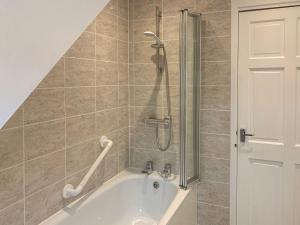 a bathroom with a shower and a bath tub at The Cottage in Salisbury +23 photos