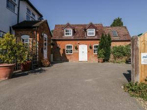 a brick house with a white door and a driveway at The Cottage in Salisbury
