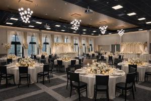 a banquet hall with white tables and chairs and chandeliers at Gateway Hotel and Conference Center in Ames +45 photos