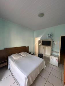 a bedroom with a white bed and a tv at Hotel Planalto in Poços de Caldas +42 photos