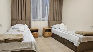 ein Schlafzimmer mit zwei Betten und einem Fenster in der Unterkunft 110 Escape in Alawerdi