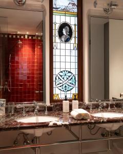 a bathroom with two sinks and a stained glass window at El Cortés, Member of Relais & Châteaux in Mexico City +13 photos