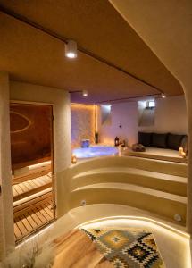 a spa room with a tub and a couch at Orama Suite & Spa in Korçë +55 photos