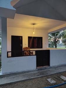 a house with a white wall and two windows at Eco Palms in Pottuvil